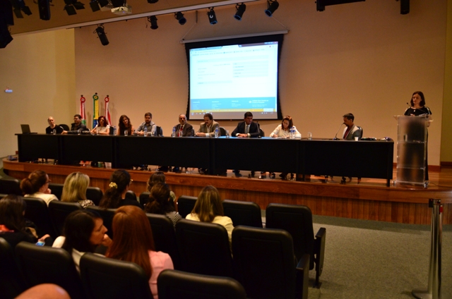Cerimônia de abertura dos cursos de especialização na área da saúde realizada na Assembleia Legislativa de Santa Catarina. Mesa composta por autoridades, incluindo o superintendente de Vigilância em Saúde, com público presente e apresentação projetada ao fundo.