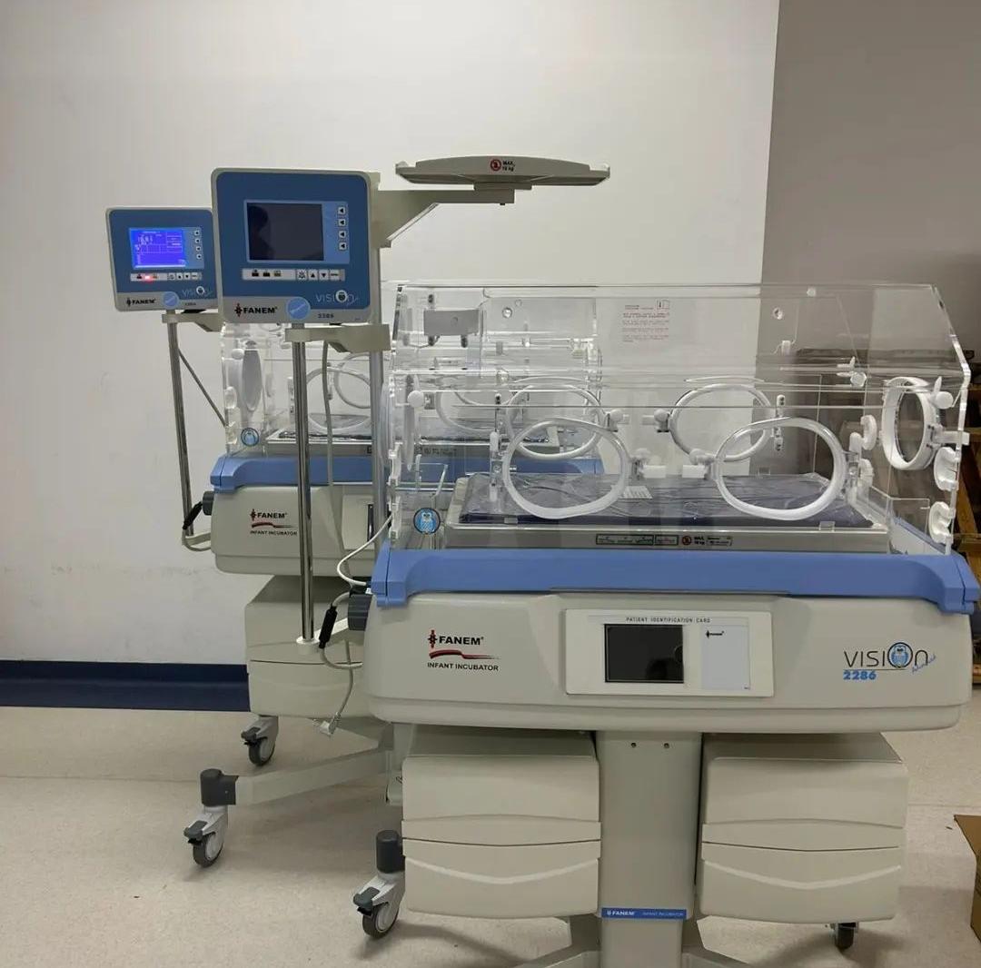 Duas incubadoras hospitalares da marca Fanem, modelo Vision 2286, em ambiente clínico. Equipamentos destinados a cuidados intensivos neonatais, com compartimentos transparentes e painéis de controle digital.