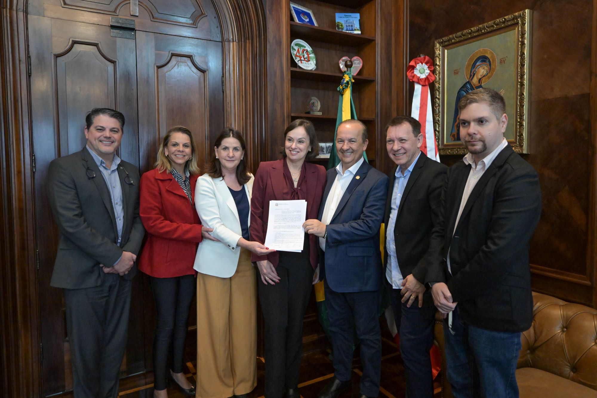Campanha de conscientização contra a dengue do Governo de Santa Catarina. A imagem mostra quatro fotos: uma mulher limpando uma tigela com plantas, um homem removendo folhas de uma calha, uma mulher fechando a tampa de uma caixa d'água e uma criança virando um pneu para evitar acúmulo de água. Abaixo, a mensagem: "Onde o mosquito não se cria, a dengue não se espalha