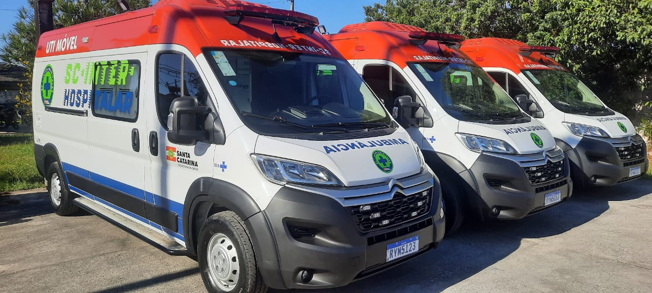 Três ambulâncias estacionadas em ambiente externo em tempo ensolarado 