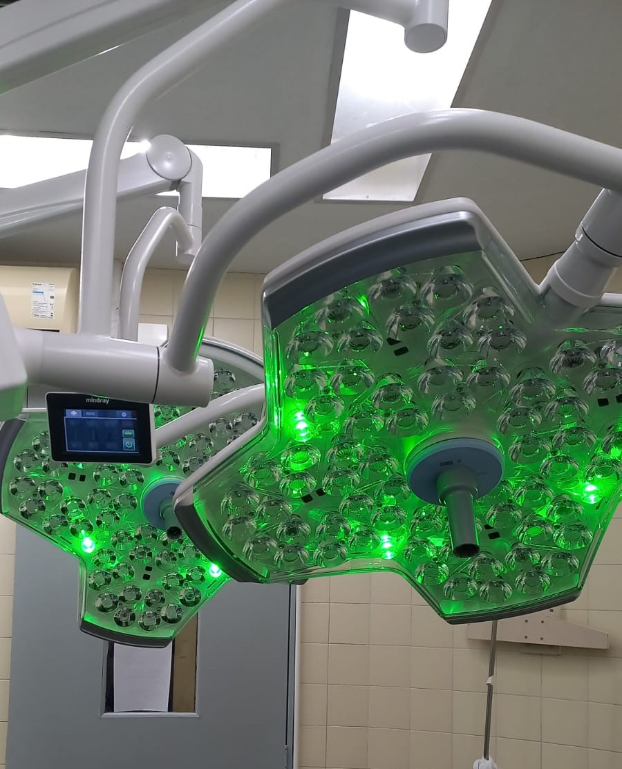 Novos focos cirúrgicos com luzes verdes instalados em sala de operação.