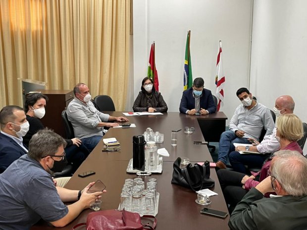 Representantes do governo de Santa Catarina e setor de eventos em reunião com bandeiras de SC, Florianópolis e Brasil ao fundo, discutindo protocolos para eventos-teste em bares e restaurantes durante a pandemia.